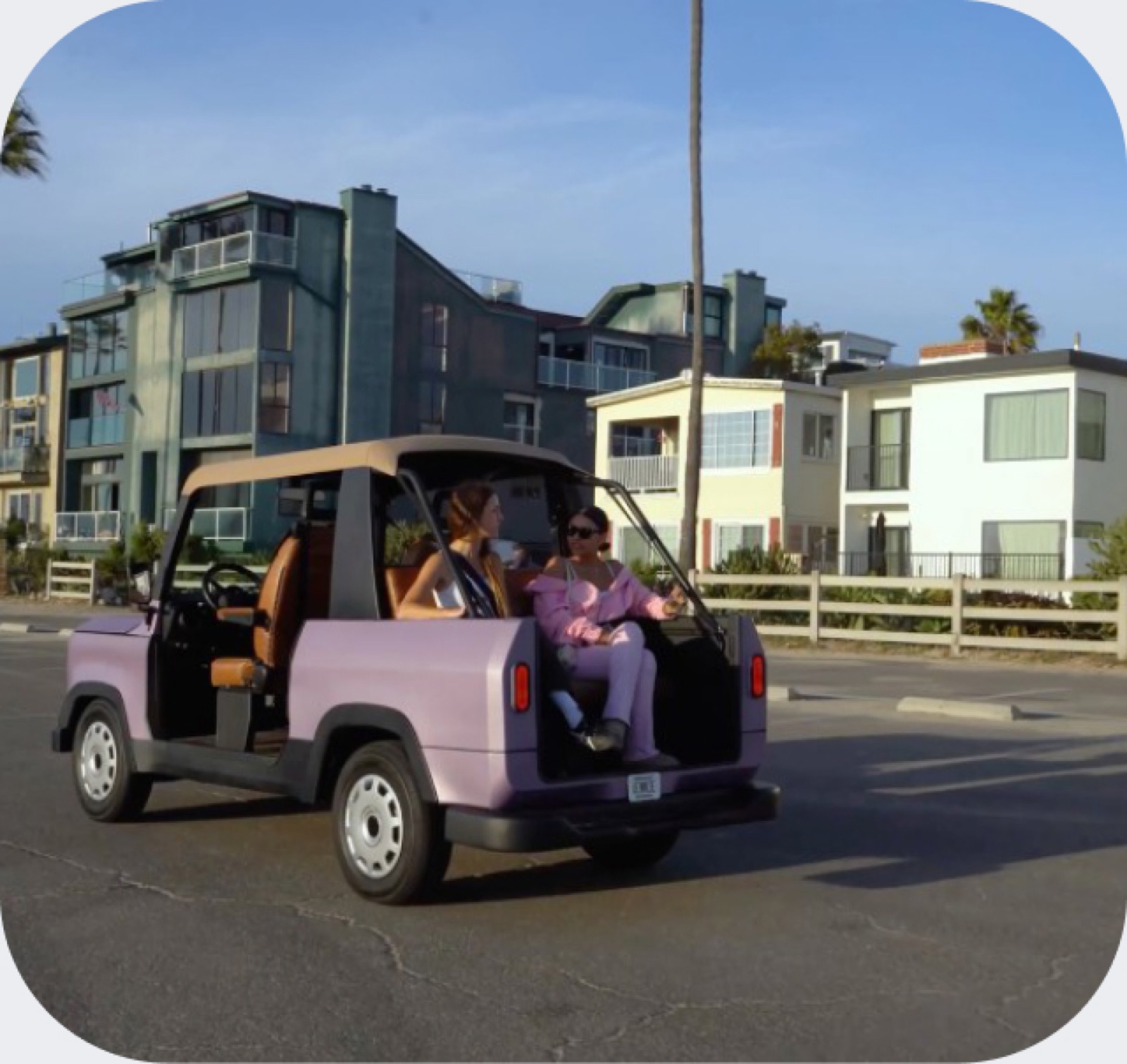 A purple Chip Motors LUV parked on a coastal street