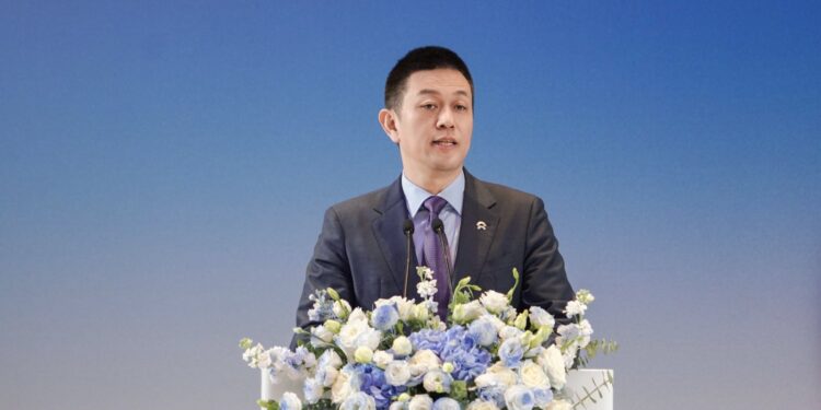 Уилям Ли от Nio представя партньорството с Geely като опит да се ограничи ожесточената конкуренция чрез споделена инфраструктура 1 Nio founder William Li speaks at a flower-adorned podium during the Geely-Nio partnership event.