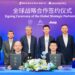Momenta and DSAT representatives hold agreement folders at a global strategic partnership signing ceremony, with executives standing behind them.